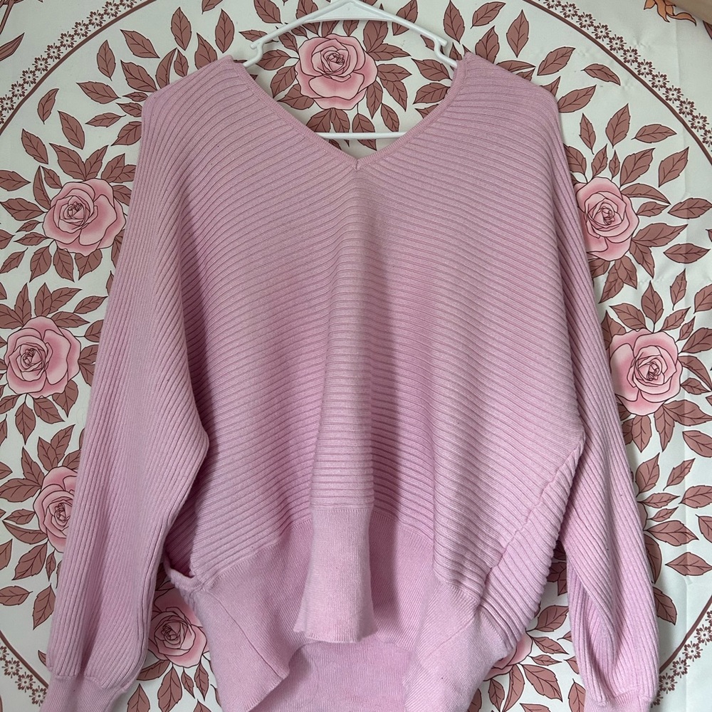 A size large pink sweater, with a low cross in the back. A little backless.